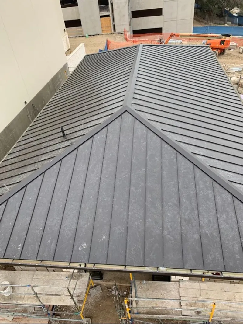 Commercial metal roof construction with crane equipment in White City